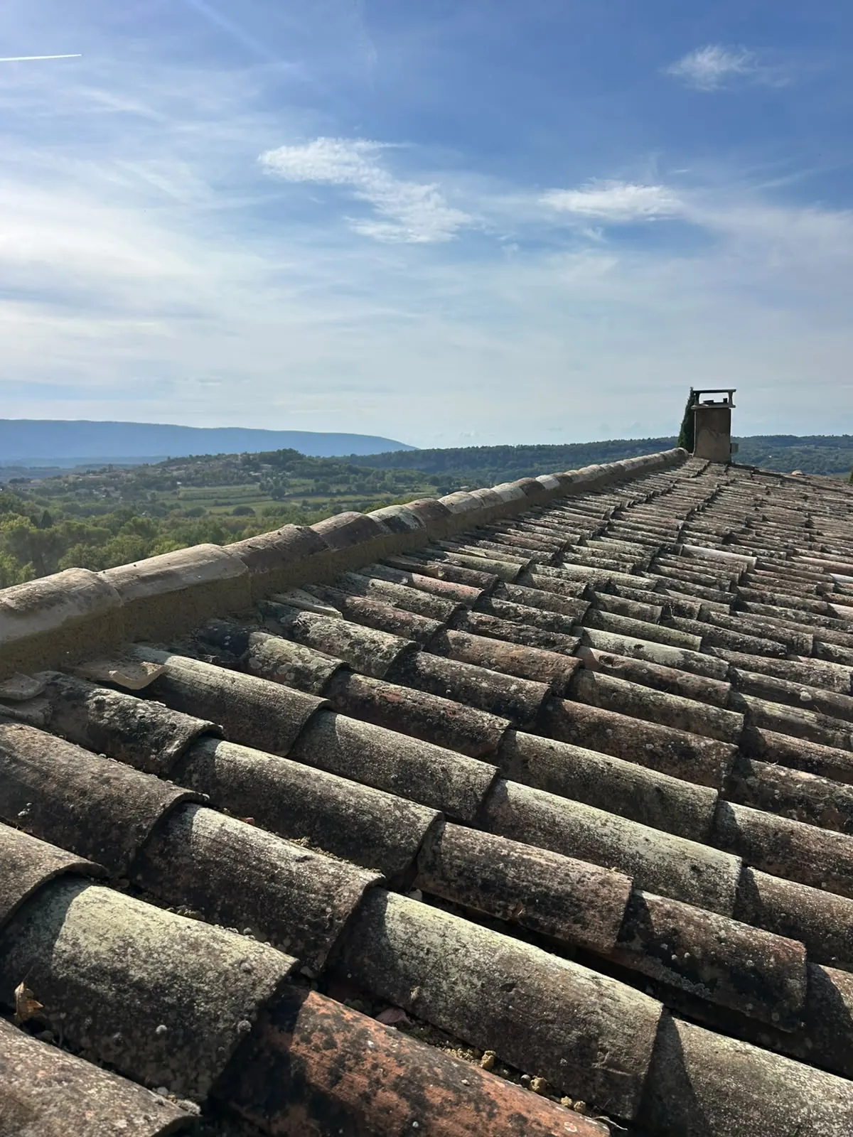 Faîtage maçonné et versant en tuiles canal anciennes avant rénovation, vue sur le Luberon
